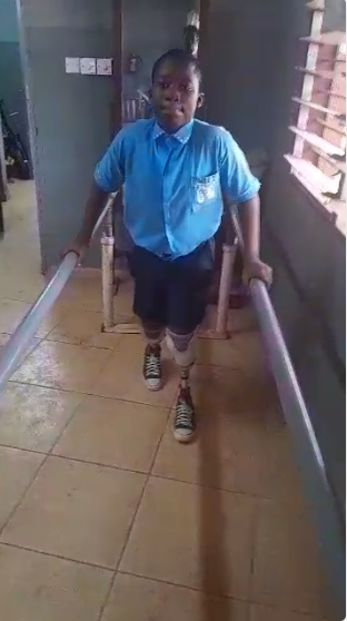 David, age 13, walking with his new prosthetic legs during gait training