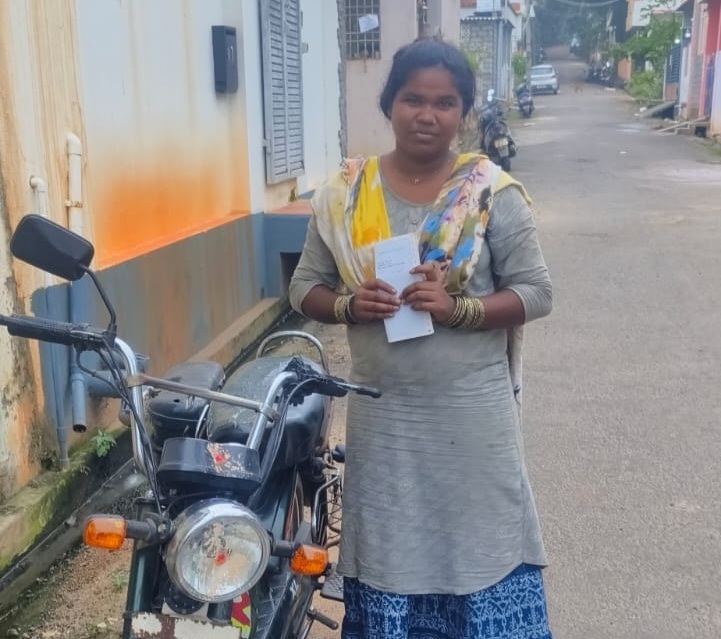 Single mother standing with her motorbike in Pondicherry