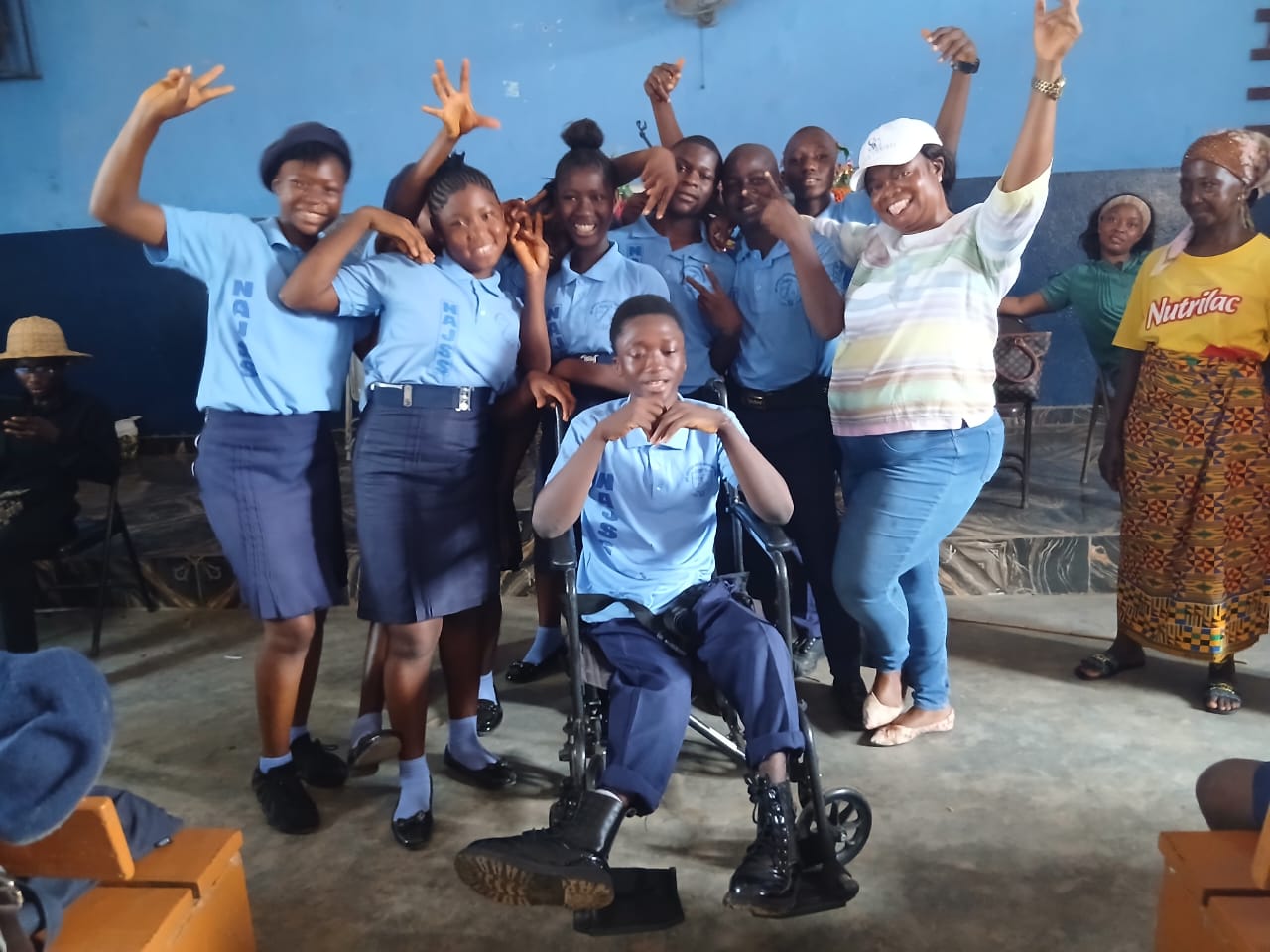 Joseph receiving his wheelchair surrounded by classmates and family